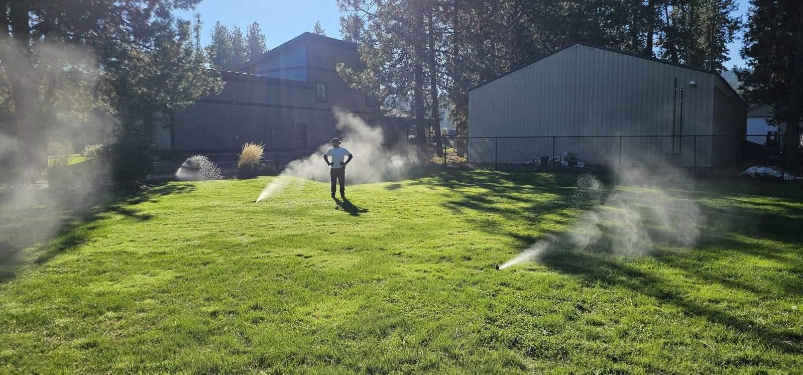 Sprinklers operating across a green North Idaho lawn